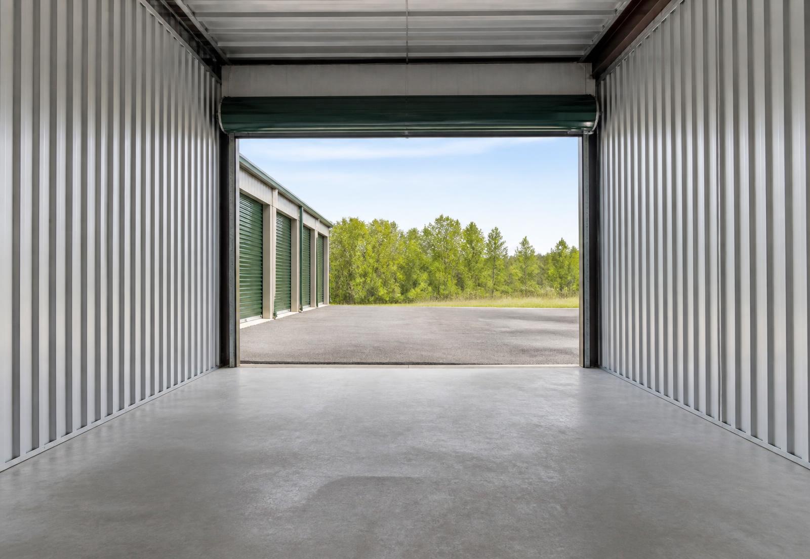 Empty storage unit with a swept concrete floor and the roll-up door open
